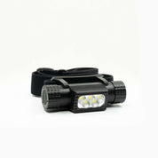 En upplyst, svart pannlampa med flera ljuskällor och ett justerbart huvudband.