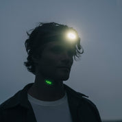 En man med en upplyst pannlampa, sedd från sidan.