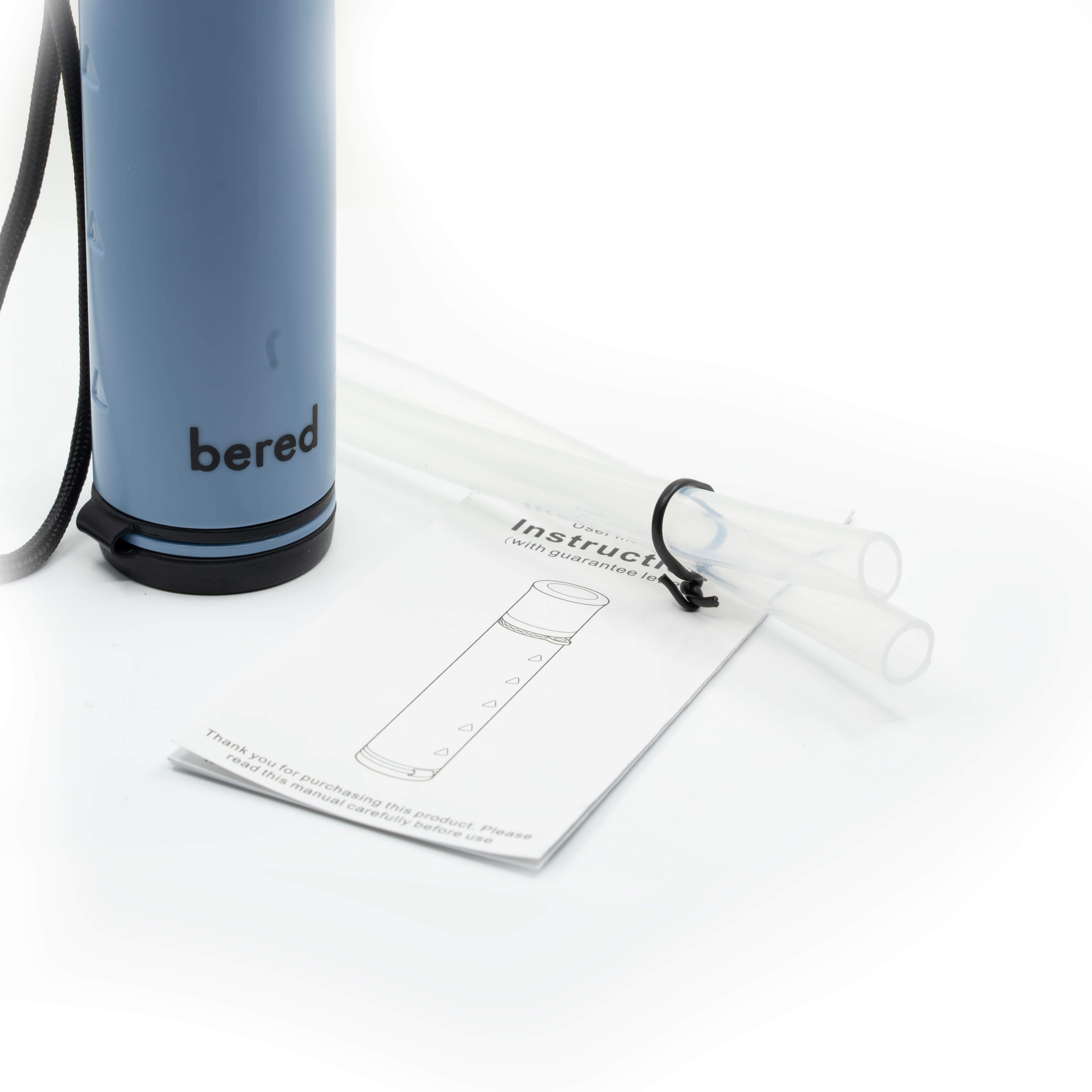 Närbild på ett ljusblått vattenfilter med texten "bered" och medföljande instruktioner samt slangar.