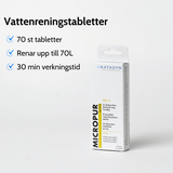 En plastikkasse med en sort fløjte og en grå stofpose ligger på et trægulv.